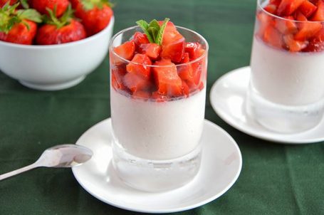 Bicchieri di panna cotta alle fragole con sopra fragole fresche