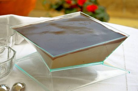 Tavola bianca in giardino con ciotola ci mousse al caffè in primo piano
