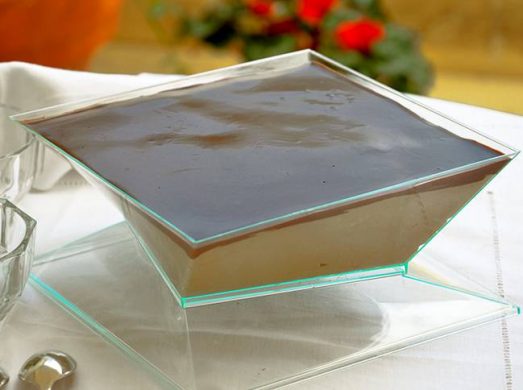 Tavola bianca in giardino con ciotola ci mousse al caffè in primo piano