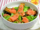 Ciotola bianca con insalata con salmone affumicato su tovaglietta