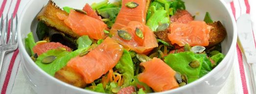 Ciotola bianca con insalata con salmone affumicato su tovaglietta