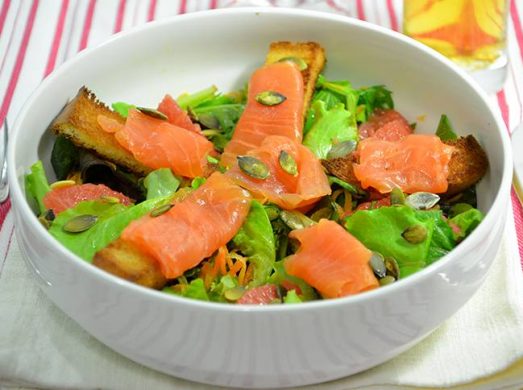 Ciotola bianca con insalata con salmone affumicato su tovaglietta