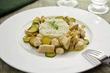 Piatto bianco con bocconcini di pollo e zucchine e riso basmati