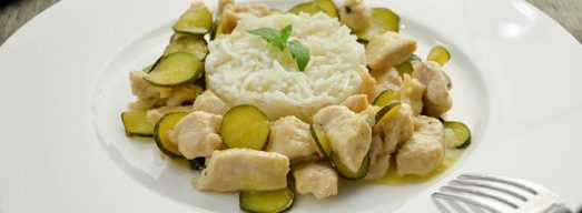 Piatto bianco con bocconcini di pollo e zucchine e riso basmati
