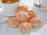 Tavola apparecchiata di bianco con biscotti al cocco in primo piano