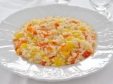 Piatto bianco con risotto ai peperoni su tovaglia bianca