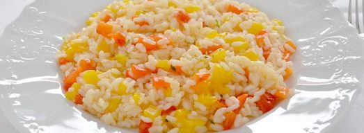 Piatto bianco con risotto ai peperoni su tovaglia bianca