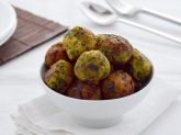 Ciotola bianca con polpette di verdure su tavola apparecchiata