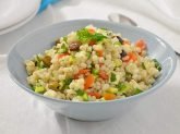 Ciotola celeste con verdura e feta su tavola bianca