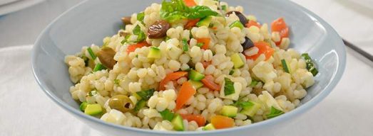 Ciotola celeste con verdura e feta su tavola bianca
