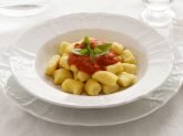 Piatto bianco elegante con gnocchi di ricotta al sugo