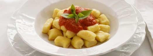 Piatto bianco elegante con gnocchi di ricotta al sugo