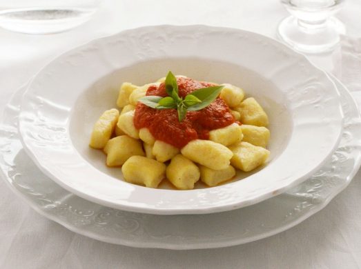 Piatto bianco elegante con gnocchi di ricotta al sugo