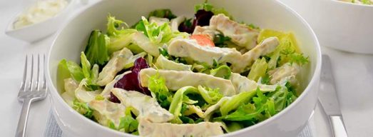 Ciotola bassa con insalata di pollo su tavaglietta a righe