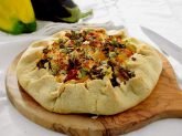 Tagliere con torta salata su tavola bianca