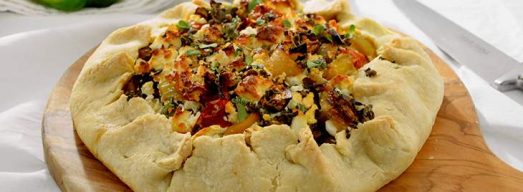 Tagliere con torta salata su tavola bianca