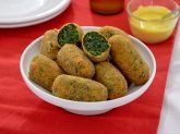 Ciotolina bianca con crocchette di spinaci su tavola rossa e bianca