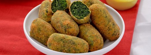 Ciotolina bianca con crocchette di spinaci su tavola rossa e bianca