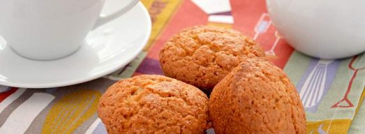Tre muffin su tovaglietta e latte e zucchero sullo sfondo