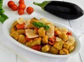 Piatto ovale di gnocchi di melanzane su tavola bianca