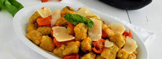 Piatto ovale di gnocchi di melanzane su tavola bianca
