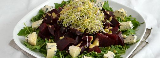Piatto piano con insalata di barbabietole su tavola apparecchiata