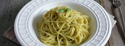 Piatto di spaghetti con pesto di salvia con salvia e pesto sullo sfondo