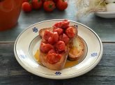 Piatto con fette di pane casereccio e pomodori scattarisciati sopra