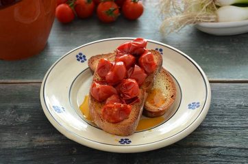 Piatto con fette di pane casereccio e pomodori scattarisciati sopra
