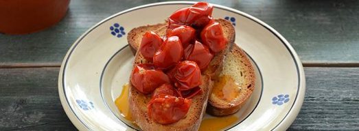 Piatto con fette di pane casereccio e pomodori scattarisciati sopra