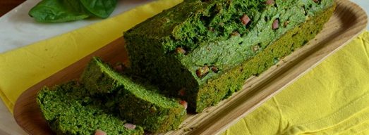 Vassoio di legno con plumcake in primo piano su tovaglietta gialla