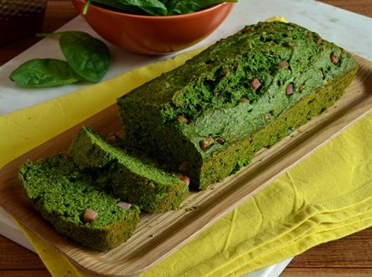 Vassoio di legno con plumcake in primo piano su tovaglietta gialla
