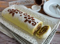 Rotolo dolce alla Nutella, con crema di nocciole e spolverata di zucchero a velo, su vassoio