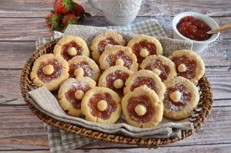 Cestino con biscotti con fragole, latte e marmellata in sfondo