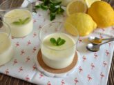 Bicchieri di lemon posset con limoni e menta freschi sullo sfondo
