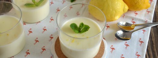 Bicchieri di lemon posset con limoni e menta freschi sullo sfondo