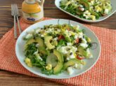 Piatto piano con insalata con uova sode e avocado su tovaglietta arancione